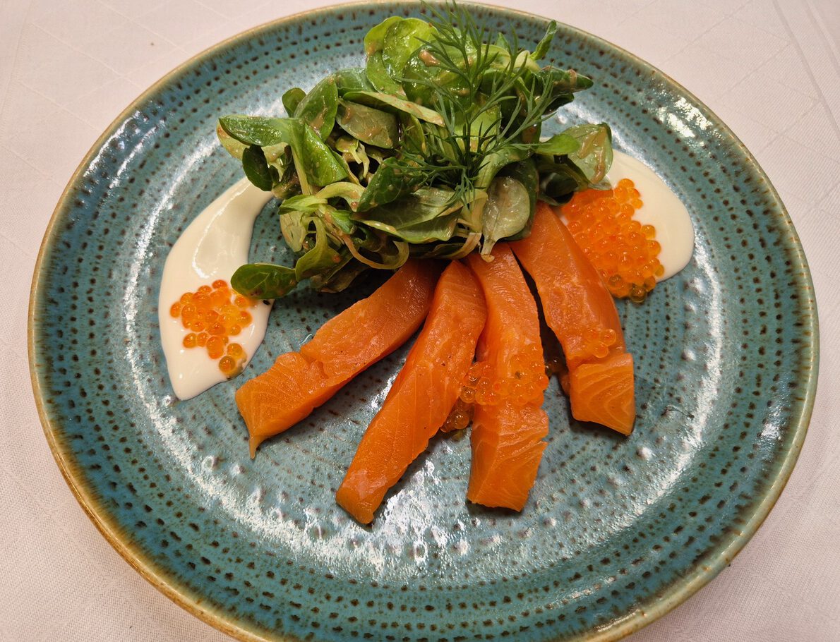 blauer Teller mit Seesaibling, Kaviar, Feldsalat