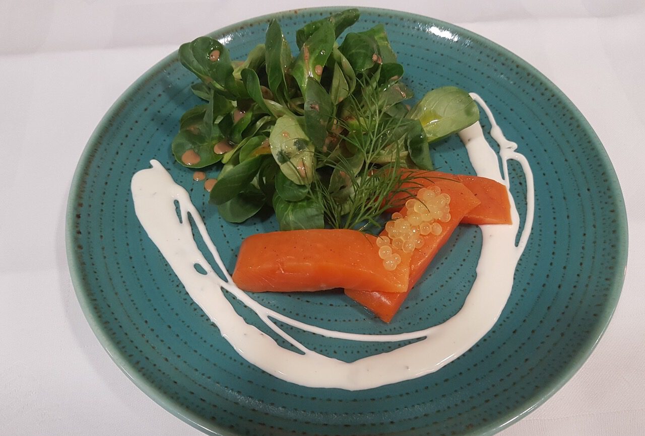 blauer Teller mit Seesaibling, Kaviar, Feldsalat